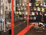 Covid-19 screen protector at a music shop with red powder coated steel tube. Guitars on the wall