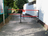 Red pedestrian restraint barrier on walkway to slow walkers down before a road. Staggered access control barrier. 