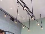 Steel tube and clamp fittings on roof of cafe with lights placed into them 