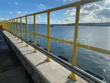 Interclamp key clamp fittings powdered coated yellow used to construct a guardrail on a jetty located on the Pembrokeshire Coast